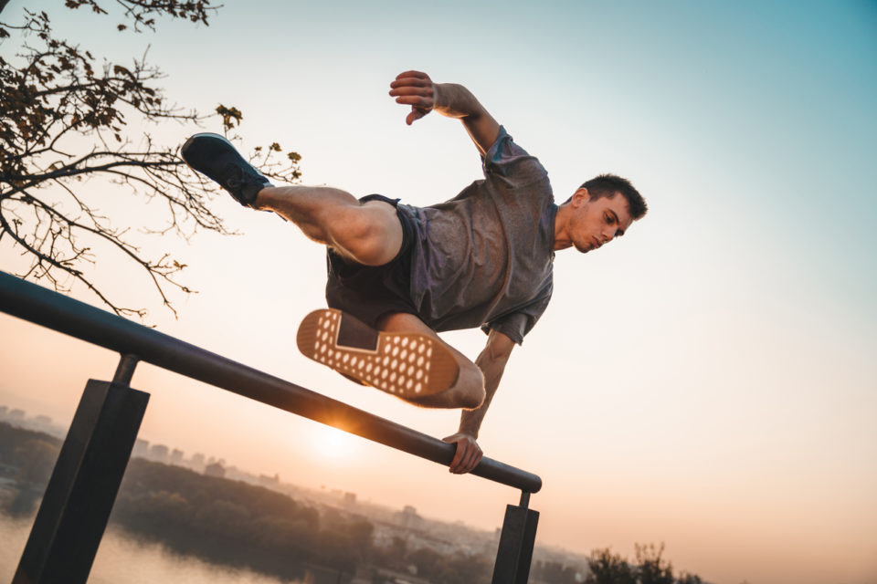 Athlete jumping over a wall for parkour.