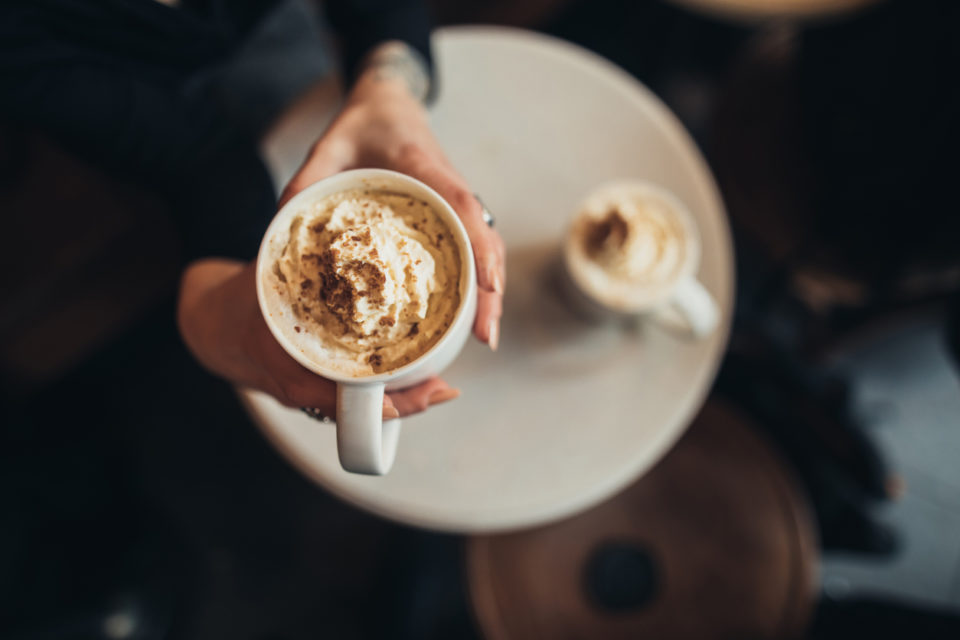 Woman holding pumpkin spice latte