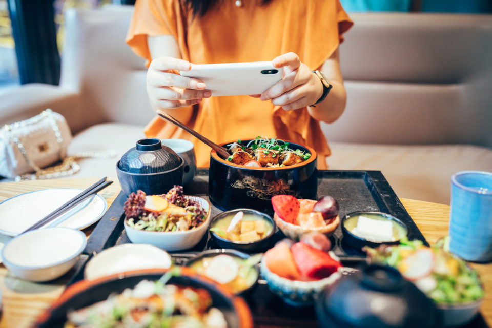 Woman taking photo of meal on her phone