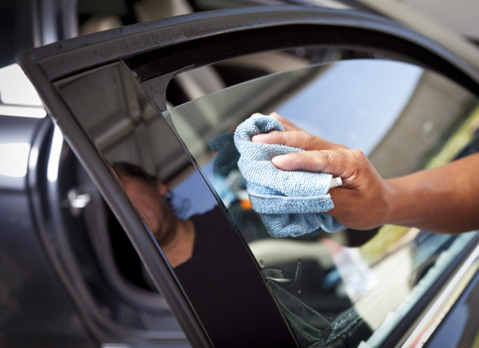 Man cleaning car window