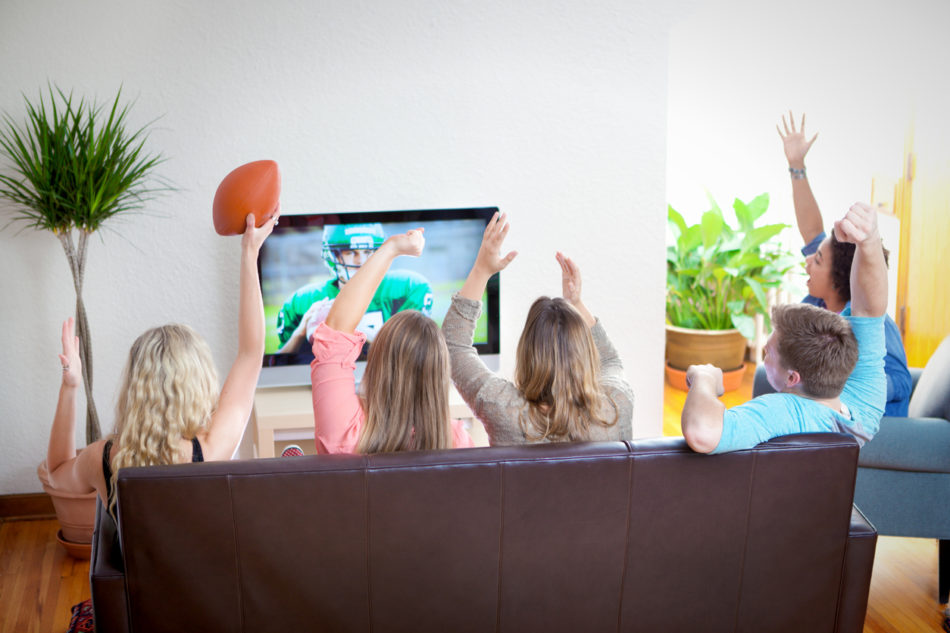 A group of young friends watching a sports football game