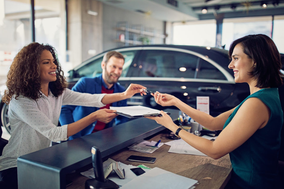 Couple is buying new car and signing the contract