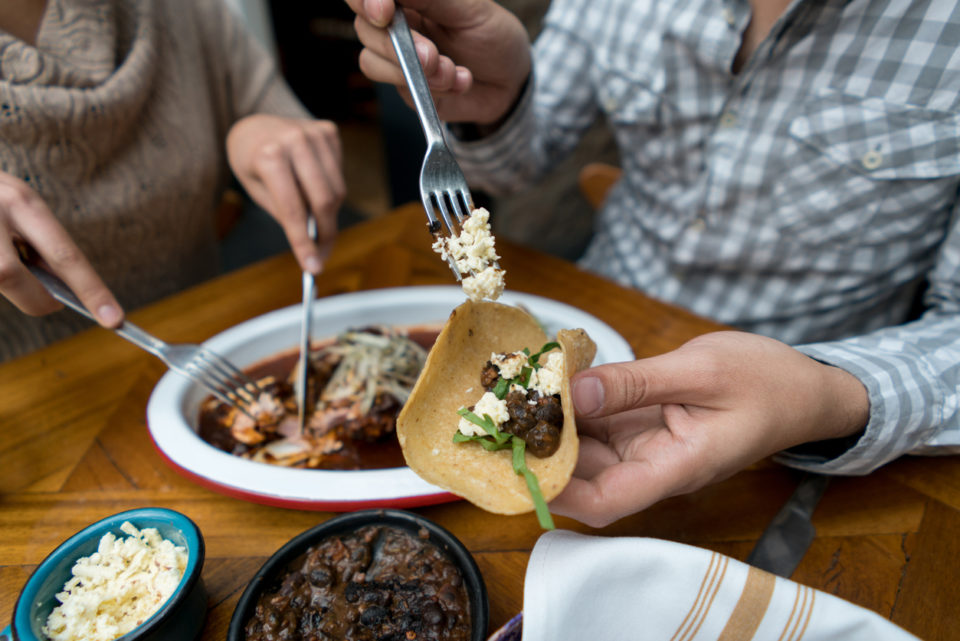 Group of friends eating tacos at a Mexican restaurant