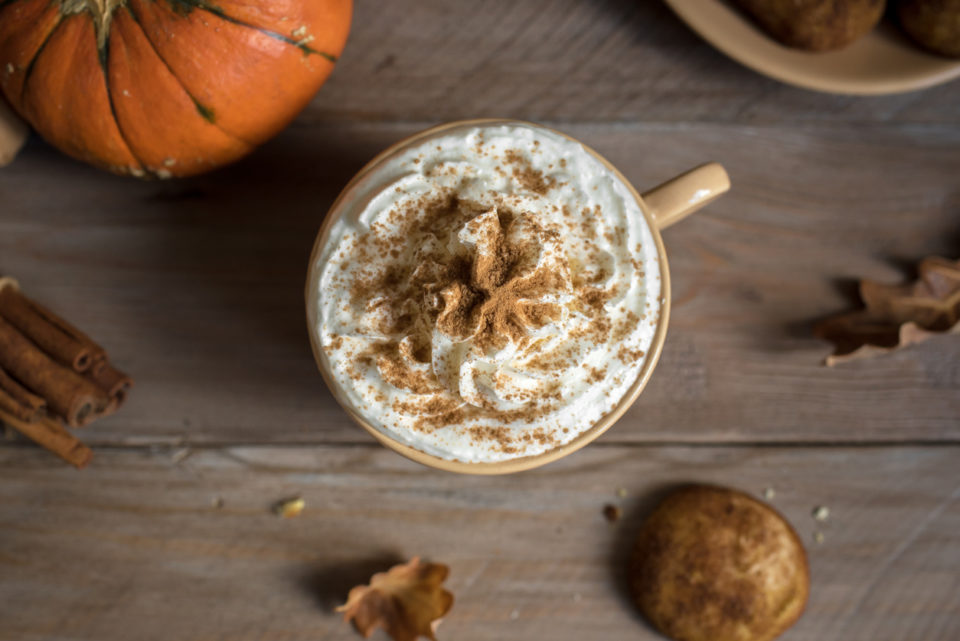 Pumpkin Spice Latte. Cup of Latte with Seasonal Autumn Spices, Cookies and Fall Decor. Traditional Coffee Drink for Autumn Holidays.