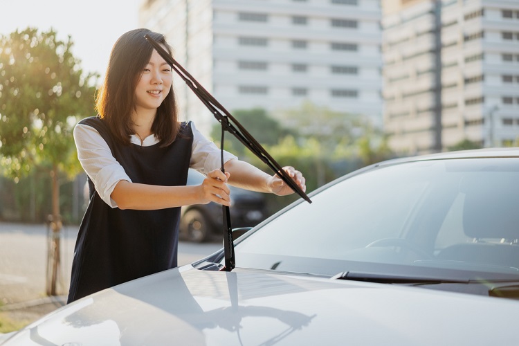 Image of an Asian Chinese woman check her windshield wiper before the journey